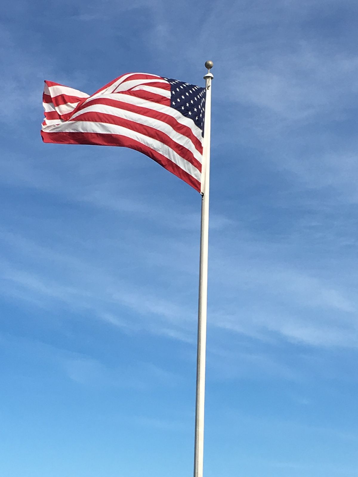 An American flag waving against a blue sky