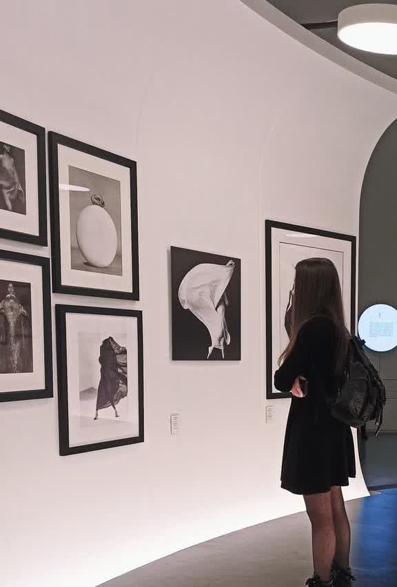 A visitor looking at framed photographs in a gallery