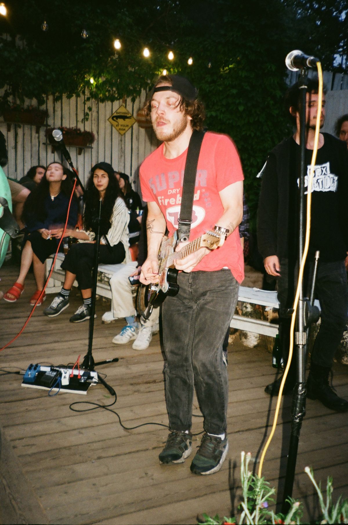 A guitarist playing an outdoor evening set