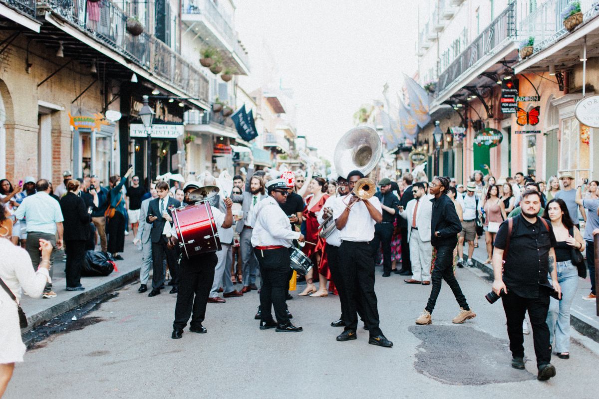 A brass band leading a street parade through a crowd
